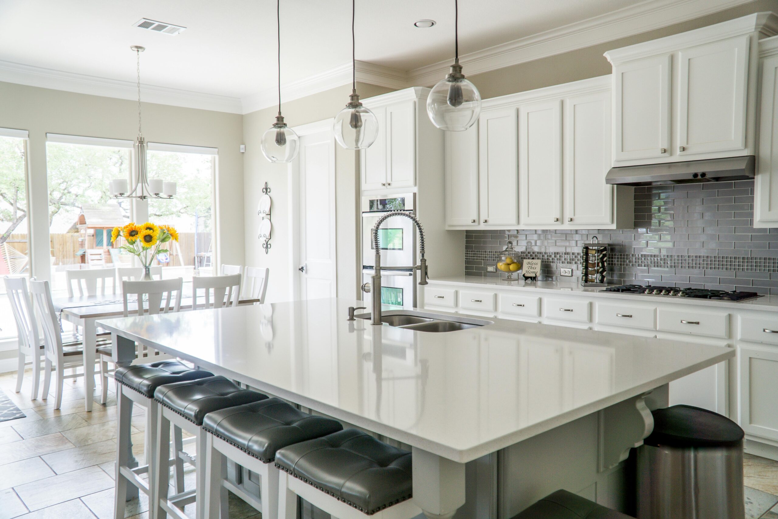 Spacious modern kitchen with white cabinets and island in natural light.